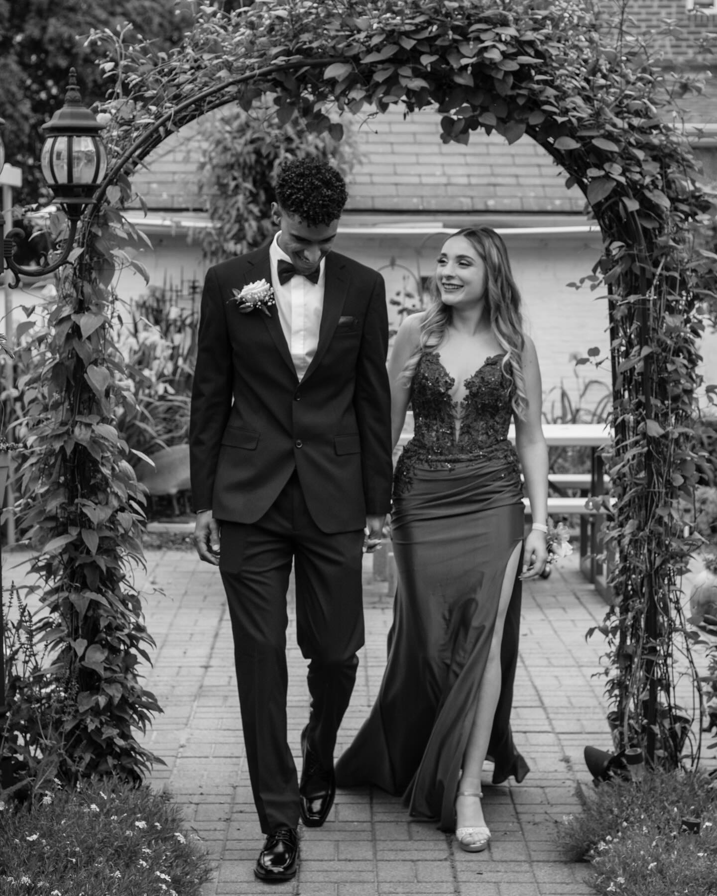 Black and white portrait of a couple under a garden arch