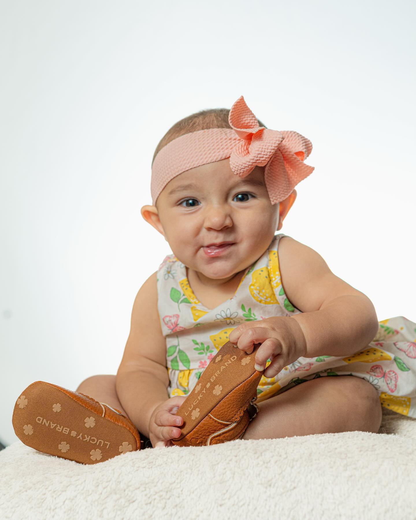 High-key studio portrait of a baby with a shoe